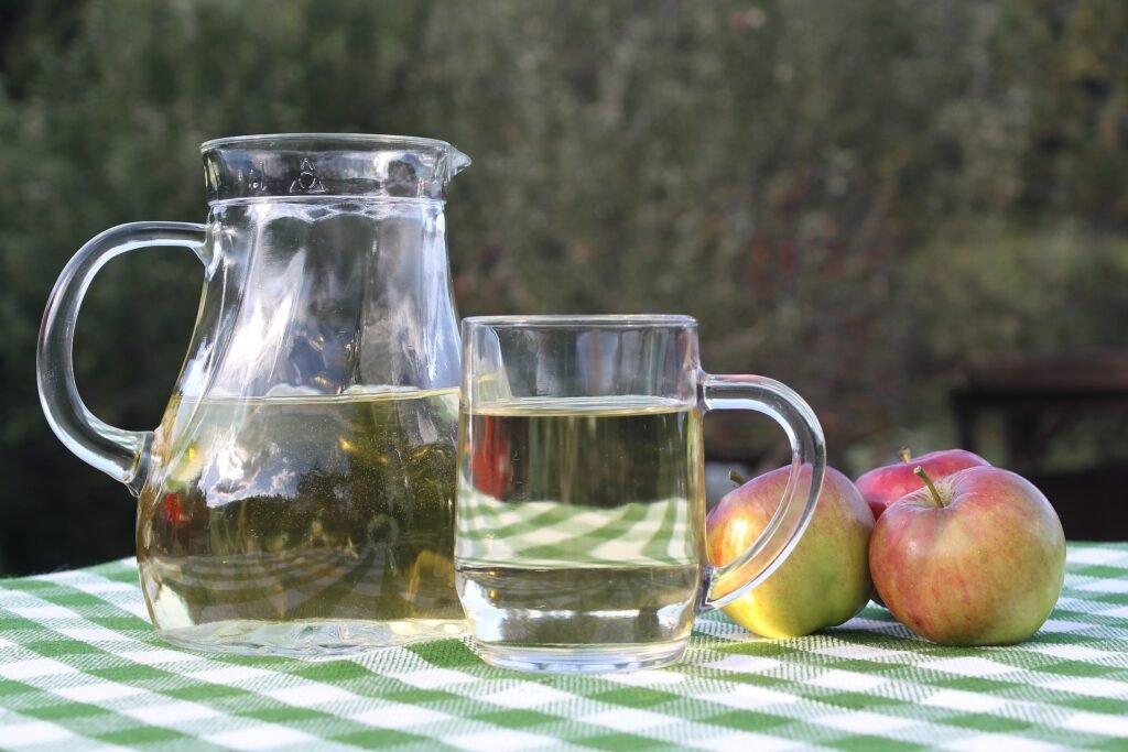 Apples and diluted apple cider vinegar drink in a jar and cup