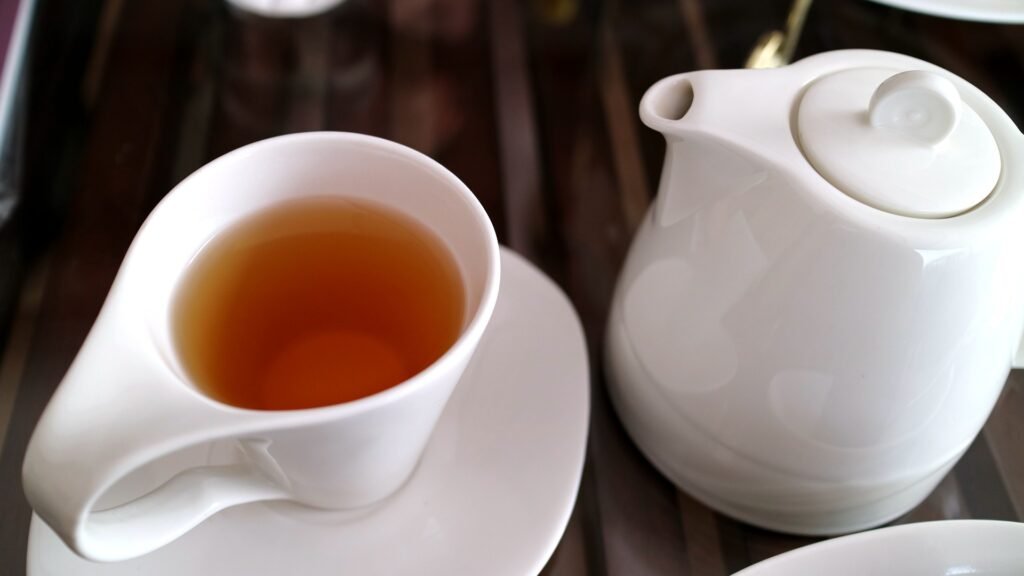 A glass mug and a tea cup with green tea