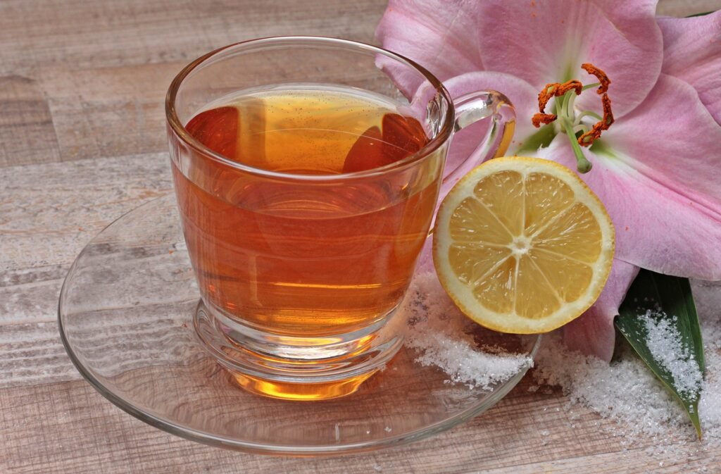 A cup filled with green tea and a sliced lemon