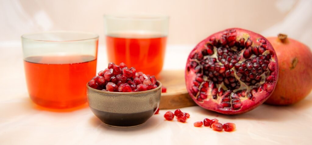 sliced Pomegranate fruits and juice in glass cup